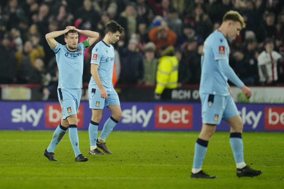 Wrexham players look dejected after Sheffield's Billy Sharp scored his side's second goalduring the FA Cup 4th round soccer match between Sheffield United and Wrexham at the Bramall Lane stadium in Sheffield, England, Tuesday, Feb. 7, 2023. (AP Photo/Jon Super)