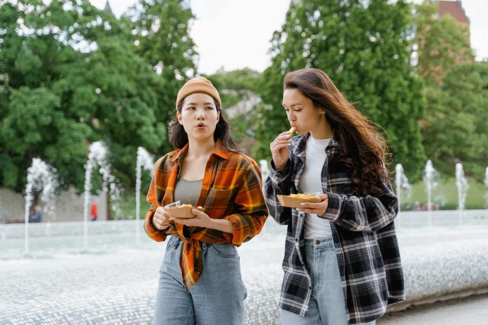 Talking while eating and eating in a rush can increase the amount of air swallowed. <a href="https://www.pexels.com/photo/women-eating-while-walking-at-the-park-8165247/" rel="nofollow noopener" target="_blank" data-ylk="slk:Photo by MART PRODUCTION/Pexels" class="link ">Photo by MART PRODUCTION/Pexels</a>, <a href="http://creativecommons.org/licenses/by/4.0/" rel="nofollow noopener" target="_blank" data-ylk="slk:CC BY" class="link ">CC BY</a>