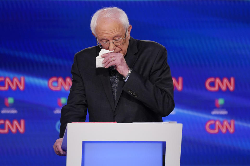 Sen. Bernie Sanders, I-Vt., wipes his nose during the Democratic presidential primary debate at CNN Studios, Sunday, March 15, 2020, in Washington. (AP Photo/Evan Vucci)