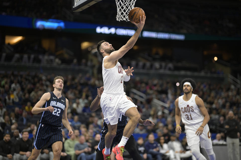 Cleveland Cavaliers guard Max Strus goes up for a shot in front of Orlando Magic center Wendell Carter Jr. as forward Franz Wagner (22) and Cavaliers center Jarrett Allen (31) watch during the first half of an NBA basketball game, Monday, Jan. 22, 2024, in Orlando, Fla. (AP Photo/Phelan M. Ebenhack)