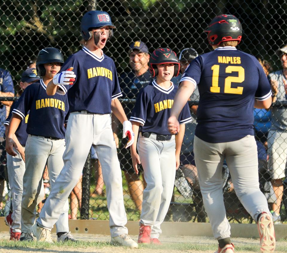 Hanover U12's Dillon Aikins, left, celebrates with teammates after Gio Naples' home run during a game against Middleboro at Forge Pond Park in Hanover on Wednesday, July 20, 2022.