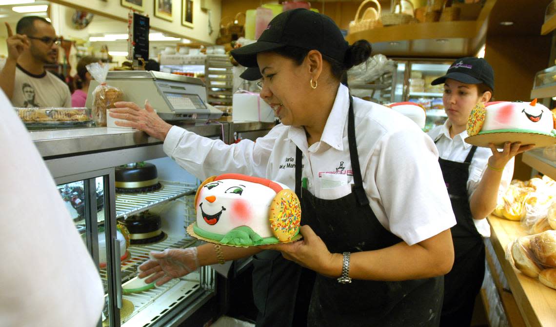 Maria Casaas, bakery manager for Epicure, helps out customers with orders of Santa cakes for the holidays. Barbara P. Fernandez/Miami Herald File / 2004
