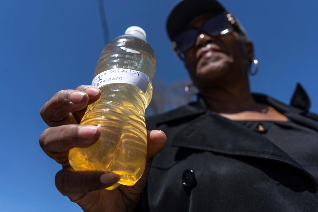 Bernice Thompson, of Flint, holds a bottle of water she said she poured from her kitchen sink on April 24, 2024, while gathered with others for the 10th anniversary commemoration of the start of the Flint water crisis march that ended at Flint City Hall on Thursday, April 25, 2024.
