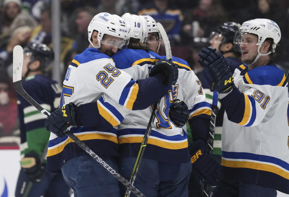 St. Louis Blues' Jordan Kyrou, from left to right, Robert Thomas, Justin Faulk and Vladimir Tarasenko, of Russia, celebrate Kyrou's third goal against the Vancouver Canucks during the third period of an NHL hockey game in Vancouver, British Columbia, on Monday, Dec. 19, 2022. (Darryl Dyck/The Canadian Press via AP)