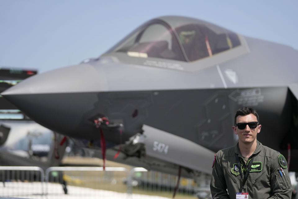 FILE - First Lieutenant Walker Gall poses in front of a F35 Lightning 2 fighter plane at the Farnborough Air Show fair in Farnborough, England, Monday, July 18, 2022. The future for fighter pilots was on display at the Farnborough International Airshow near London, one of the world’s biggest aviation, defense and aerospace expos. New technologies take on a bigger role in the cockpit, redefining what it means to be a ''Top Gun''. (AP Photo/Frank Augstein, File)