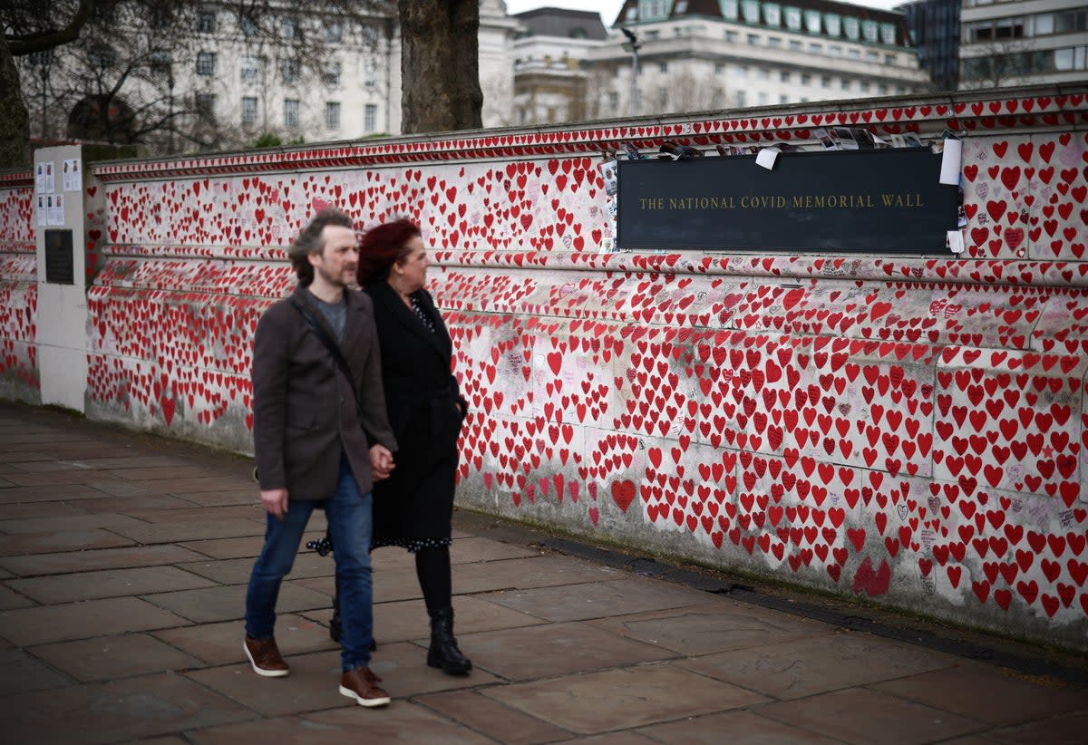 People walk past messages written on The National Covid Memorial Wall, on the third anniversary of the United Kingdom going into a national lockdown (REUTERS)