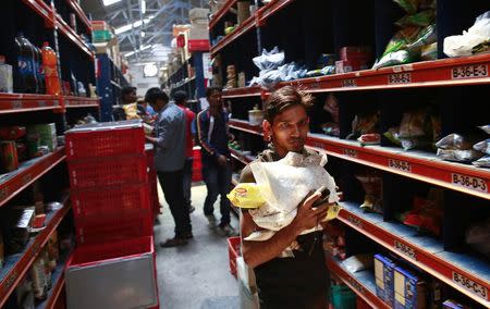 An employee carries goods at a Big Basket warehouse on the outskirts of Mumbai November 4, 2014. REUTERS/Danish Siddiqui