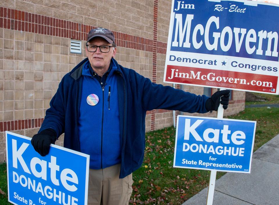 Kelly Roney holds signs for Kate Donaghue and Jim McGovern outside the Trottier Middle School voting place in Southborough, Nov. 8, 2022.