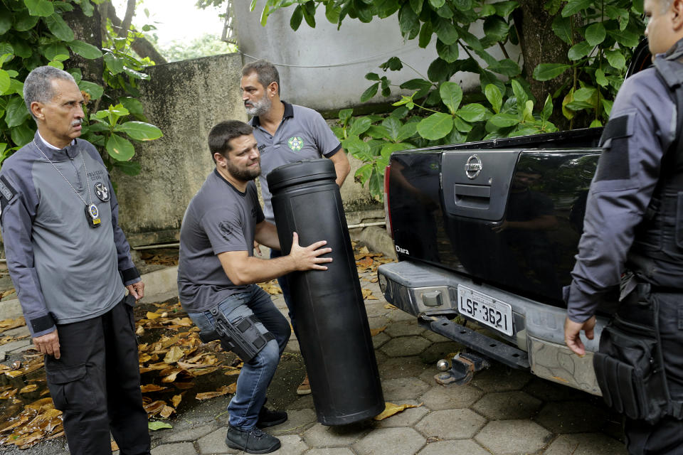 A Civil Police officer carries a case confiscated from the home of suspects in the killing of councilwoman Marielle Franco at the Civil Police headquarters in Rio de Janeiro, Brazil, Tuesday, March 12, 2019. Police in Brazil arrested two suspects in the killing of Franco and her driver. The brazen assassination of the two on March 14 last year led to massive protests and widespread anger in Latin America's largest nation. (AP Photo/Silvia Izquierdo)