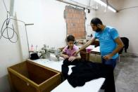 Muhamed (L), a Syrian refugee boy, and his father Mahmud Awwal work at a small textile factory in Istanbul, Turkey, June 24, 2016. REUTERS/Murad Sezer