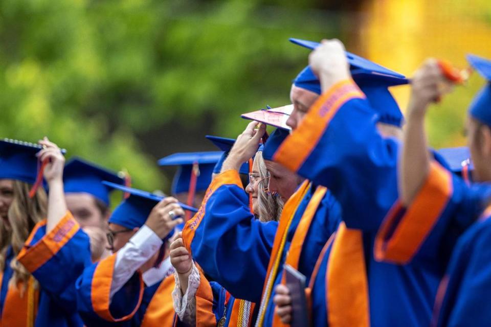 Macy Dungan, center right, and her classmates move the tassels on their mortarboards near the end of their commencement ceremony outside Frankfort High School on Friday, May 21, 2021.