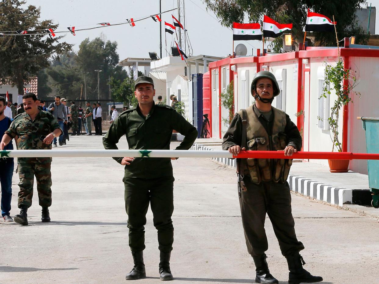 Syrian army officers guard their side of the Quneitra border crossing to the Israeli annexed-Golan Heights during its reopening: Louai Beshara/AFP/Getty Images