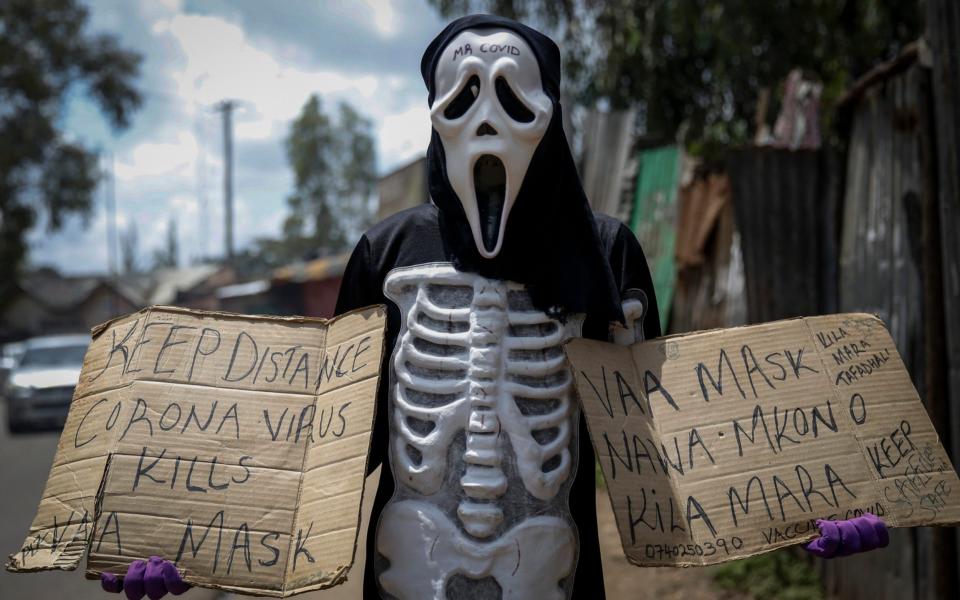 James Kiriva, 35, who took the initiative to educate his community about the importance of taking precautions to curb the spread of the coronavirus and COVID-19, walks around dressed as a skeleton to spread his message in English and Swahili in the Kibera low-income neighborhood of Nairobi, Kenya - Brian Inganga / AP