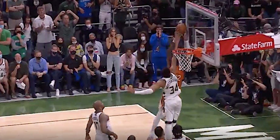 Giannis Antetokounmpo blocks a dunk attempt by Deandre Ayton.