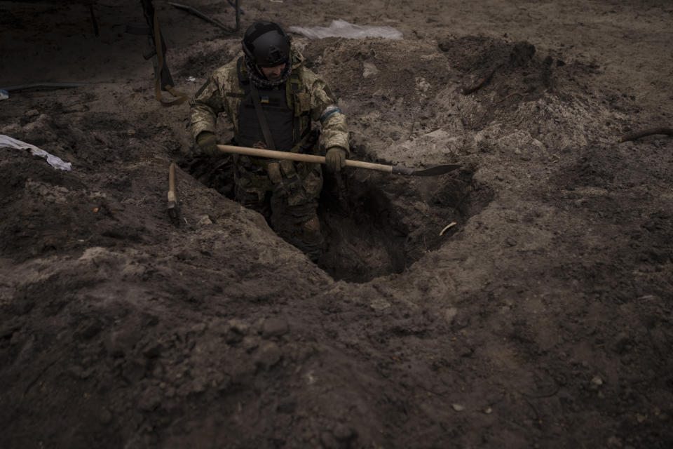 A Ukrainian soldier digs a foxhole in Irpin, outskirts of Kyiv, Ukraine, Sunday, March 13, 2022. (AP Photo/Felipe Dana)