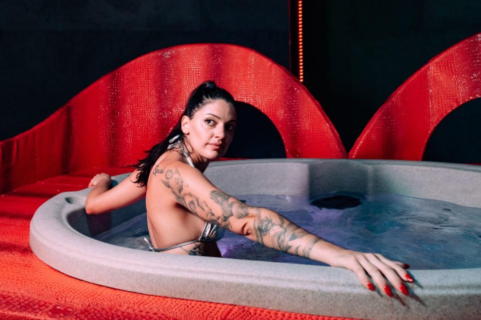 A woman sits in a hot tub.