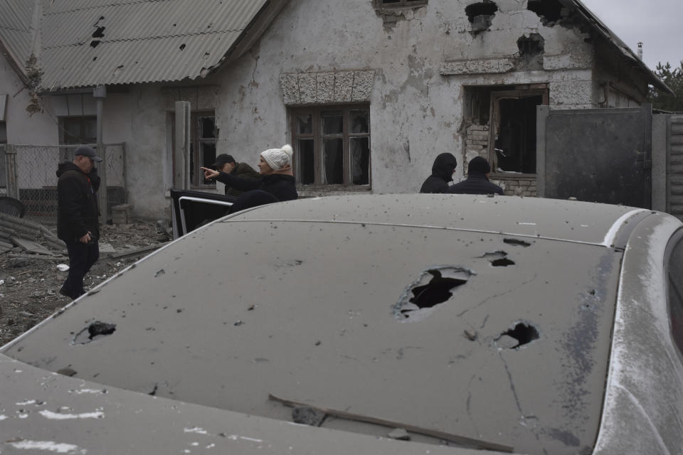 Local residents look at their home damaged in Russia's air attack in Zaporizhzhia, Ukraine, Friday, Dec. 29, 2023. (AP Photo/Andriy Andriyenko)