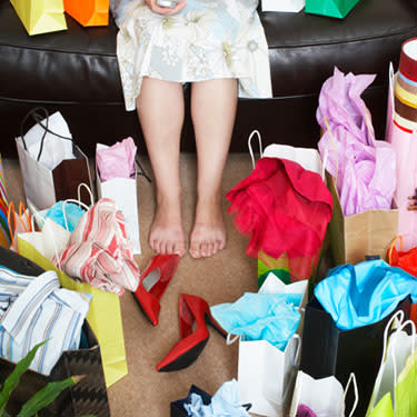 Woman-sitting-on-sofa-surrounded-with-shopping-bags_web