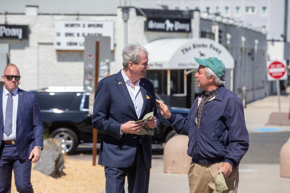 Gov. Phil Murphy greets Asbury Park Mayor John Moor as he visits small businesses on the Asbury Park boardwalk to call attention to his proposal to create a "boardwalk fund" as part of the state budget in Asbury Park, NJ Thursday, May 25, 2023. The fund would help towns repair their boardwalks, a move he thinks is vital to economic development.