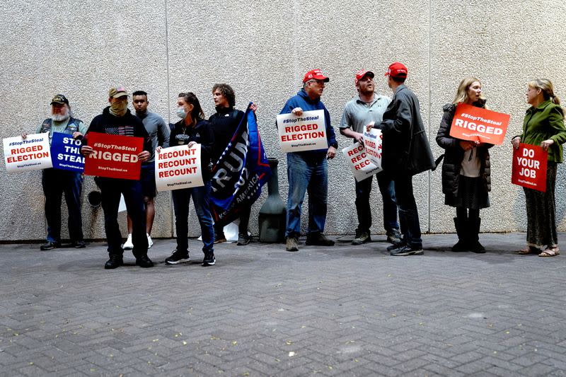 Supporters of U.S. President Donald Trump hold placards at a "Stop the Steal" protest outside Milwaukee Central Count the day after all of Milwaukee County's absentee ballots were counted, in Milwaukee