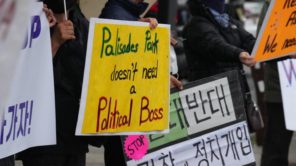 Palisades Park residents rally in front of the town's municipal building to demand action from Mayor Paul Kim and council members to address problems with the Police Department