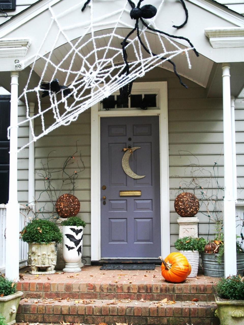 <p>Craft an oversize spiderweb above your front porch with <a href="http://www.instructables.com/id/Gigantic-Halloween-Spider-Web/" rel="nofollow noopener" target="_blank" data-ylk="slk:clothesline style rope;elm:context_link;itc:0;sec:content-canvas" class="link ">clothesline style rope</a> or by simply tying together strands of white Christmas tinsel garland. Don't have great DIY skills? Buy a giant spiderweb for your home on Etsy. </p>