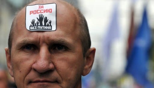 A man takes part an anti-Putin protest in Moscow. The sticker reads: For Russia without Putin!