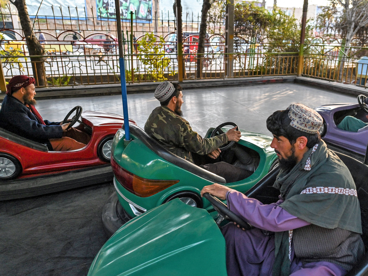 In this picture taken on 23 November, 2021, Taliban fighters ride on bumper cars, while they visit a small amusement park in Herat city, Herat (Getty Images)