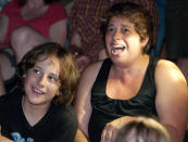 Sally Russell, right, of Minneapolis reacts with her son Henry Roach, 11, as the first videos begin at the Walker Art Center's first "Internet Cat Video Film Festival," showcasing the best of cat films on the Internet in Minneapolis Thursday, Aug. 30, 2012. The Walker Art Center in Minneapolis held its first-ever online cat video festival, a compilation of silly cat clips that have become an Internet phenomenon, attracting millions of viewers for some of the videos. (AP Photo/Craig Lassig)