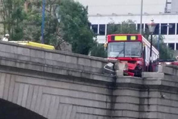 A passenger bus has been left hanging off a bridge over the River Thames after an accident in London yesterday