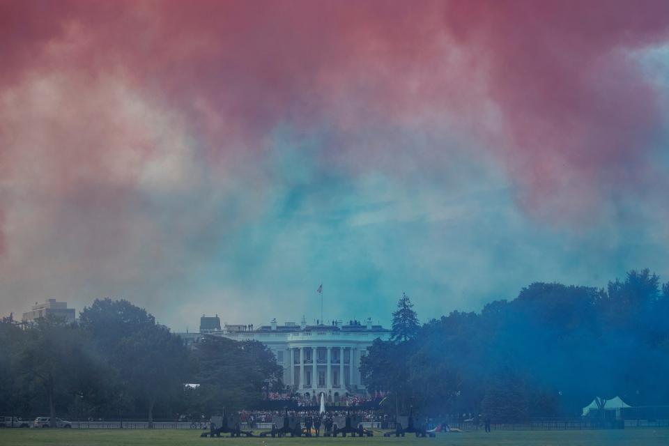 The White House in obscured by Red and Blue smoke floating on the Ellipse during a &quot;Salute to America&quot; event on the South Lawn of the White House, Saturday, July 4, 2020, in Washington.