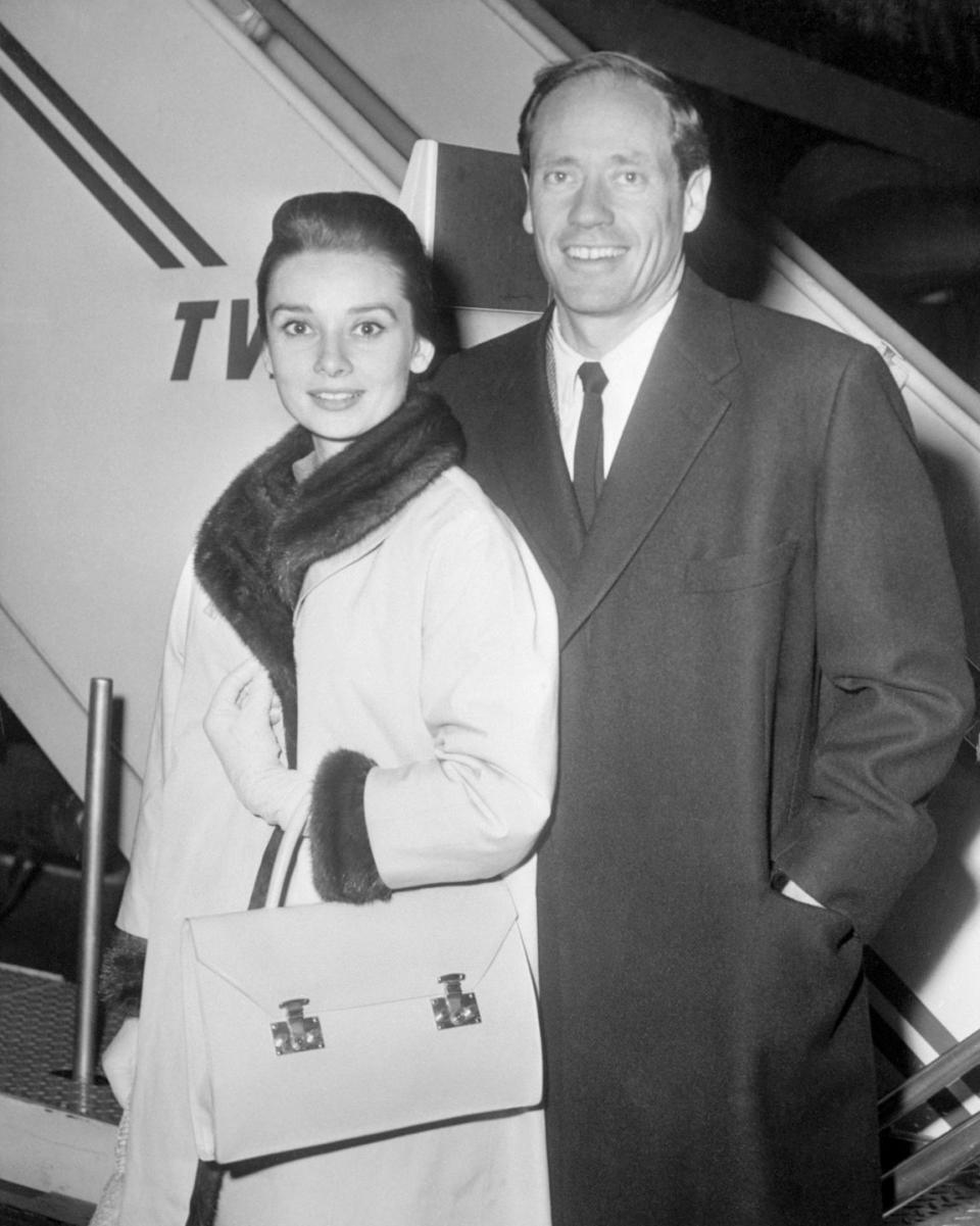 <p>The actress and her husband, Mel Ferrer, look chic as they depart New York's Idlewild Airport (now John F. Kennedy International Airport) to celebrate Christmas in Europe. </p>