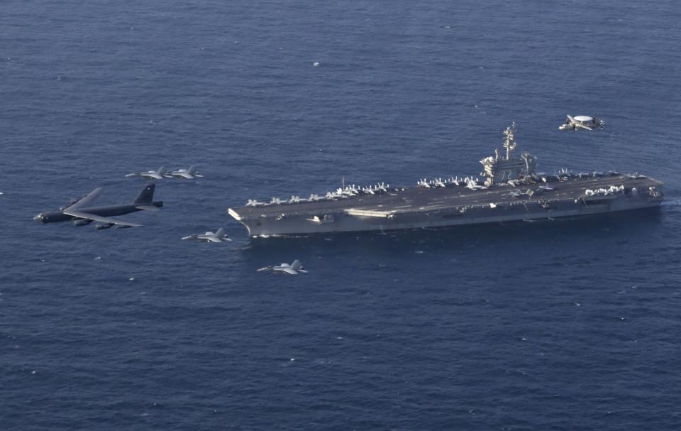 FILE - In this June 1, 2019 file photo, the USS Abraham Lincoln carrier and a U.S. Air Force B-52H Stratofortress, conduct joint exercises in the U.S. Central Command area of responsibility in Arabian sea. For decades considered a U.S. national security priority, the Persian Gulf remains home to tens of thousands of American troops spread across sprawling bases protecting crucial routes for global energy supplies. But while U.S.-Iran tensions in the Gulf appeared close to sparking a global conflagration this summer, attention now rapidly has shifted to Syria. (Mass Communication Specialist 1st Class Brian M. Wilbur/U.S. Navy via AP, File)