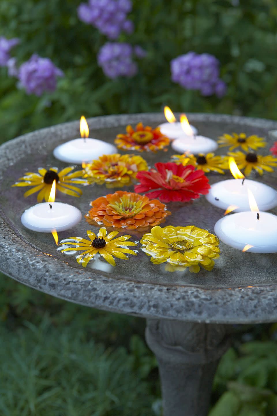 <p>Bobbing black-eyed Susans and zinnias, plus floating candles, turn an everyday birdbath into an instantly elegant water feature.</p>