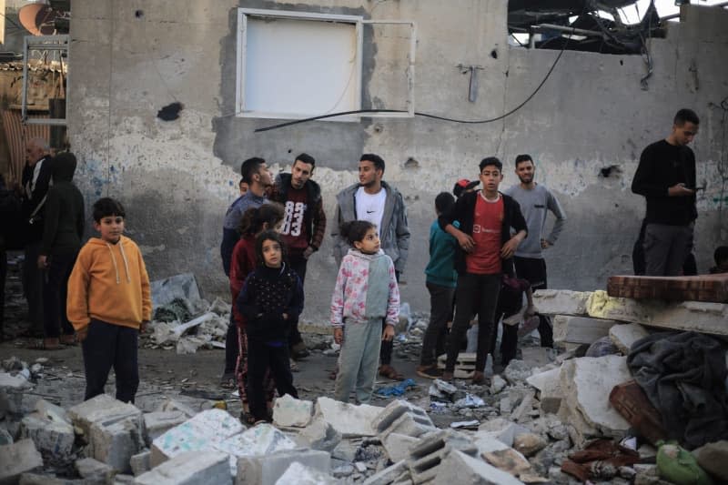 People inspect a damaged building after an Israeli raid on Rafah in the southern Gaza Strip as battles continue between Israel and the Palestinian Hamas movement. Mohammed Talatene/dpa