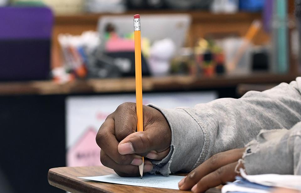 In this Thursday, Nov. 7, 2019, photo, a student at Crosby High School works in class in Waterbury, Conn. While students in the Waterbury public school district are predominantly black and Hispanic, the vast majority of its educators, as in school districts across the country, are white. (AP Photo/Jessica Hill)