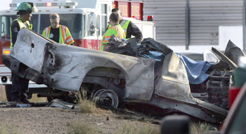 Emergency personnel are next to a burned truck that was traveling east in the the west bound lanes of Interstate 10 and struck a tour bus Tuseday Nov. 20, 2012 in Casa Grande, Ariz. The driver of the truck was killed, two people were flown to Phoenix hospitals and six were transported to Casa Grande Regional Medical Center. The collision is under investigation by Arizona Department of Public Safety Highway Patrol.(AP Photo/Casa Grande Dispatch, Oscar Perez)