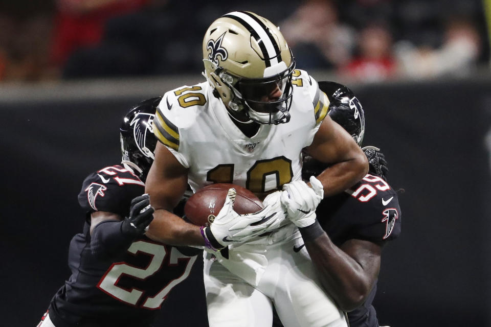 New Orleans Saints wide receiver Tre'Quan Smith (10) makes the catch against Atlanta Falcons strong safety Damontae Kazee (27) during the first half of an NFL football game, Thursday, Nov. 28, 2019, in Atlanta. (AP Photo/John Bazemore)