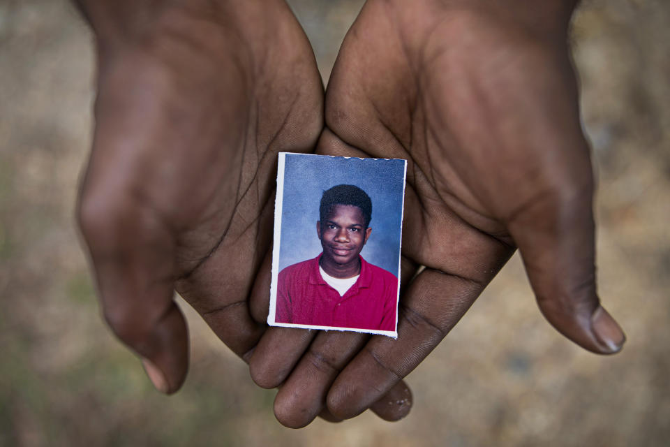 FILE - In this Monday, June 10, 2019, file photo, Joshua Love, 36, holds a photograph of himself taken at about the time he says he was sexually abused at St. Francis of Assisi School by two Franciscan friars, Brother Paul A. West and the late Brother Donald Lucas, in Greenwood, Miss. Love and his cousin La Jarvis Love have accused West, once a Franciscan friar and fourth-grade teacher, of molesting them while they were elementary-school students. West has been extradited from his home state of Wisconsin to Mississippi. (AP Photo/Wong Maye-E, File)