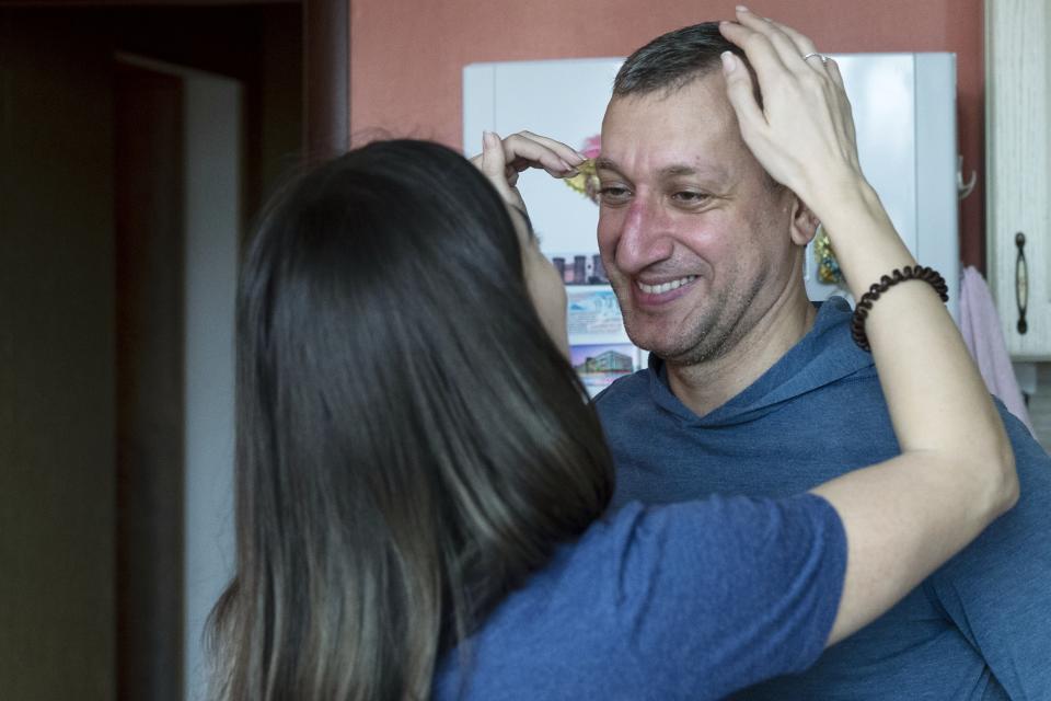 In this photo taken on Saturday, May 16, 2020, Dr. Osman Osmanov is greeted by his wife Saida after a shift at an intensive care unit of Filatov City Clinical Hospital in Moscow, Russia. Moscow accounts for about half of all of Russia's coronavirus cases, a deluge that strains the city's hospitals and has forced Osmanov to to work every day for the past two months, sometimes for 24 hours in a row. (AP Photo/Pavel Golovkin)