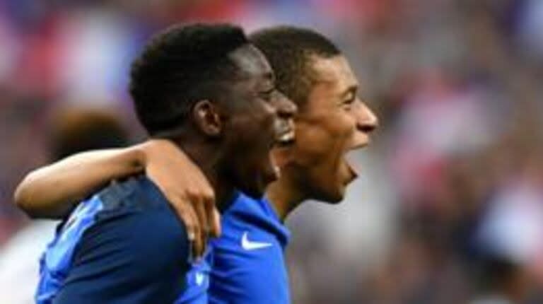 Mbappé y Dembélé se abrazan en el festejo de un gol de Francia.