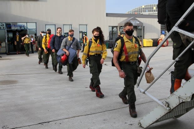 Wildland firefighters from Alberta board a plane bound for Ontario on Thursday. (Alberta Wildfire/Twitter - image credit)