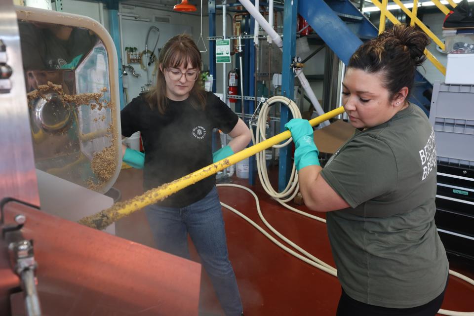Bell Tower’s Jenna Morgan and co-founder Bridget Tipton clean out the mash from a tank.