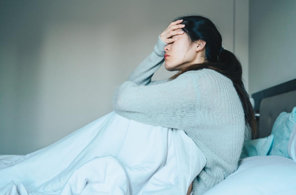 Approximately 30% of people who get COVID-19 develop long-term symptoms, or long COVID-19. <a href="https://www.gettyimages.com/detail/photo/portrait-of-sickness-woman-sitting-alone-on-the-bed-royalty-free-image/1222224164?adppopup=true" rel="nofollow noopener" target="_blank" data-ylk="slk:Boy Anupong/Moment via Getty Images;elm:context_link;itc:0;sec:content-canvas" class="link ">Boy Anupong/Moment via Getty Images</a>