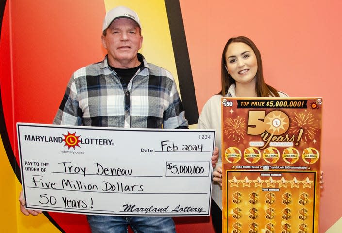 Troy Deneau and his wife, Rachel, of Dorchester County are all smiles after he won the second of three $5 million top prizes in the Maryland Lottery's 50 Years! scratch-off game.