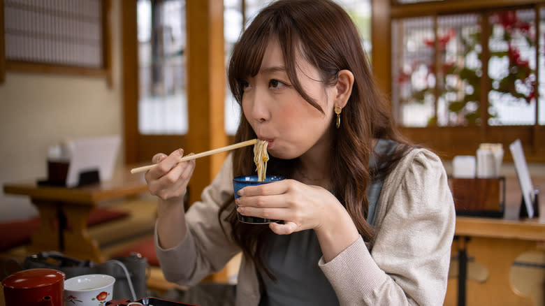 person eating soba noodles