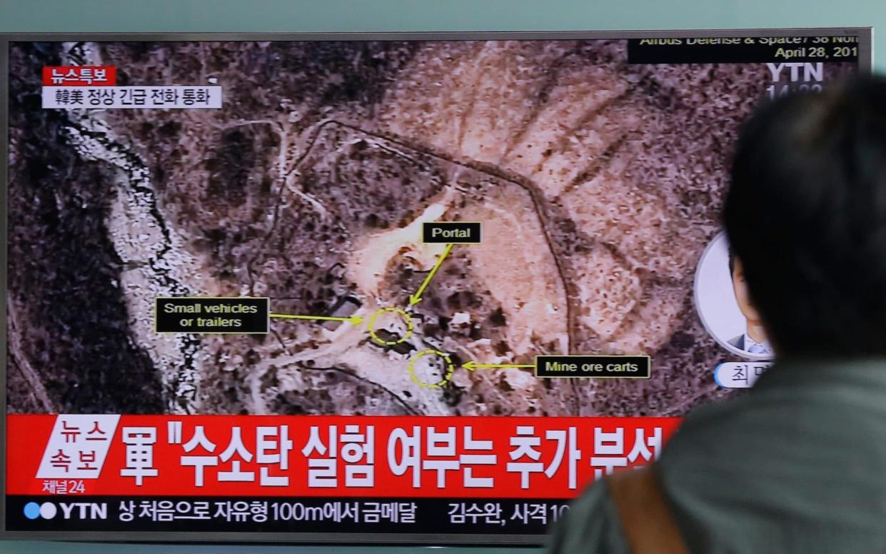 A man watches a TV news programme reporting North Korea's nuclear test last year - AP