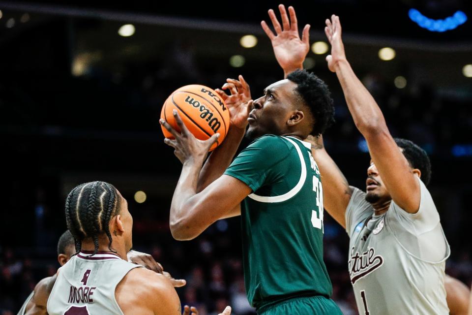 Michigan State forward Xavier Booker (34) is defended by Mississippi State guard Shakeel Moore (3) and forward Tolu Smith (1) during the second half of NCAA tournament West Region first round at Spectrum Center in Charlotte, N.C. on Thursday, March 21, 2024.