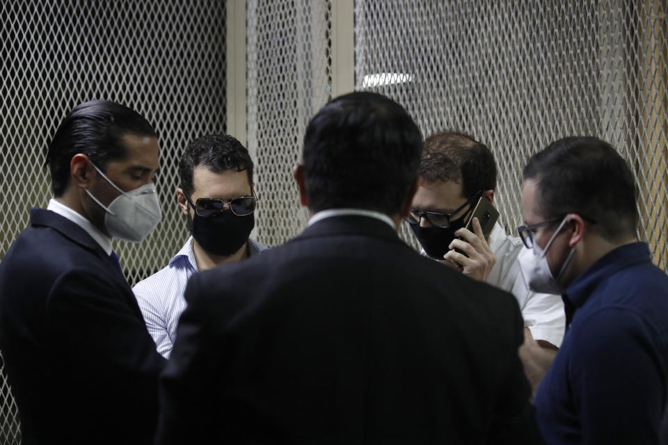 The sons of former Panamanian President Ricardo Martinelli, Ricardo Martnelli Linares, center left, and his brother Luis Enrique Martinelli Linares, center right, are accompanied by their lawyers before a hearing at the judicial court building in Guatemala City, Monday, July 6, 2020. Guatemalan police detained the Martinelli brothers on an Interpol warrant for money laundering, as they attempted to board a private plane out of the country. (AP Photo/Moises Castillo)