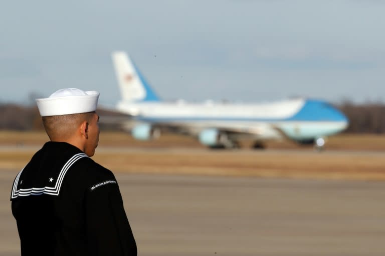 A sailor from the USS George H.W. Bush watches as the plane carrying the casket of former US president George H.W. Bush arrives at Andrews Air Force Base